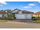 Two-story house with white double garage doors and landscaping at 275 Toscavilla Blvd, Nokomis, FL 34275