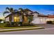 House exterior featuring a two-car garage and lush landscaping at 275 Toscavilla Blvd, Nokomis, FL 34275