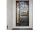 Elegant dark-stained front door with a sidelight and a lovely wreath at 275 Toscavilla Blvd, Nokomis, FL 34275