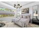 Luxurious main bedroom with large bed, chandelier, and water view at 275 Toscavilla Blvd, Nokomis, FL 34275