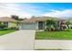 Single-story house with a two-car garage, palm trees, and well-maintained lawn at 2831 Whispering Pine Ln, North Port, FL 34287