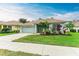 Single-story home with light gray exterior, tile roof, and landscaped lawn at 2831 Whispering Pine Ln, North Port, FL 34287