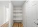 White pantry with three shelves and wood flooring at 3054 Markridge Rd, Sarasota, FL 34231