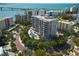 Stunning aerial view of luxury high-rise condos, showcasing manicured landscaping and a sparkling pool at 325 Golden Gate Pt # 703, Sarasota, FL 34236