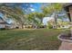 Large grassy backyard with mature trees and neighboring homes at 3530 Tree Line Dr # 4, Sarasota, FL 34231