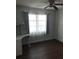 Bedroom with large window, wood-look floors, and ceiling fan at 406 Barlow Ave # 65, Sarasota, FL 34232