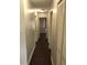 Long hallway with dark floors and multiple doors at 406 Barlow Ave # 65, Sarasota, FL 34232