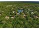 Community aerial view showcasing houses, lake, and lush greenery at 4410 Little John Trl, Sarasota, FL 34232