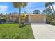 Tan house with a two-car garage and palm trees in the front yard at 4410 Little John Trl, Sarasota, FL 34232