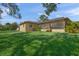 Back exterior view showing house with screened porch and green lawn at 4410 Little John Trl, Sarasota, FL 34232