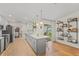 Modern kitchen with gray island, white countertops and a view into the dining area at 4410 Little John Trl, Sarasota, FL 34232