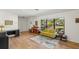 Living room with yellow couch, hardwood floors, and large window at 4410 Little John Trl, Sarasota, FL 34232