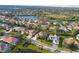 Aerial view showing neighborhood homes, landscaping, and a central lake at 4677 Sweetmeadow Cir, Sarasota, FL 34238