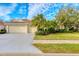 Attractive single-story home with a three-car garage and lush landscaping at 4677 Sweetmeadow Cir, Sarasota, FL 34238