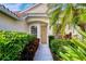 Inviting house entrance with lush landscaping and a light brown door at 4677 Sweetmeadow Cir, Sarasota, FL 34238