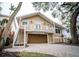 Tan two-story house with a large driveway and mature landscaping at 5169 Oxford Dr, Sarasota, FL 34242