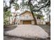 Tan two-story house with a large driveway and mature landscaping at 5169 Oxford Dr, Sarasota, FL 34242