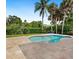 Freeform pool with a large travertine deck and tropical landscaping at 5169 Oxford Dr, Sarasota, FL 34242