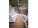 White wooden stairs leading down from a deck to the backyard at 5169 Oxford Dr, Sarasota, FL 34242