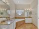 Bright bathroom featuring a soaking tub with travertine tile and granite countertops at 5171 51St W Ln, Bradenton, FL 34210