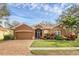 Charming single-story home with well-manicured lawn and brick driveway, lovely landscaping and a beautiful blue sky at 5171 51St W Ln, Bradenton, FL 34210