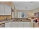 Kitchen overlooking living space, featuring light granite countertops, white cabinetry, and stainless appliances at 5171 51St W Ln, Bradenton, FL 34210