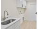 Laundry room with white cabinets, a utility sink, and light flooring at 5270 Adina Cir, North Port, FL 34291