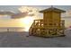 Sunset view of beach with lifeguard stand at 5855 Midnight Pass Rd # 520, Sarasota, FL 34242