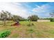 Large backyard with overgrown grass and some equipment at 6307 30Th E Ave, Palmetto, FL 34221