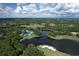 Aerial view of golf course, lake, and clubhouse at 7220 Kensington Ct, University Park, FL 34201