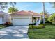 Tan house with a two car garage, and nicely landscaped yard at 7220 Kensington Ct, University Park, FL 34201