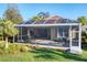 Home exterior showcasing a large screened lanai and lush landscaping at 7220 Kensington Ct, University Park, FL 34201