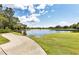 Landscaped golf course with a calm pond and walking path at 7220 Kensington Ct, University Park, FL 34201