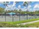 Tennis courts with people playing a match on a sunny day at 7220 Kensington Ct, University Park, FL 34201