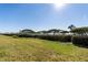 Expansive green backyard featuring manicured hedge and views of water in the distance at 73 Tidy Island Blvd, Bradenton, FL 34210