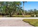 Paver driveway leading to lush green space, with a variety of mature trees at 73 Tidy Island Blvd, Bradenton, FL 34210