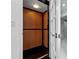 A residential elevator with a sleek, black frame and wood panels provides convenient access between floors at 73 Tidy Island Blvd, Bradenton, FL 34210