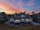 Sunset view of the rear of home showing balconies, landscaped yard, and neutral exterior paint at 73 Tidy Island Blvd, Bradenton, FL 34210