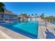 Large swimming pool with clear blue water and comfortable lounge chairs, overlooking the waterfront and community buildings at 73 Tidy Island Blvd, Bradenton, FL 34210