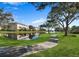 Curved path meanders through a lush green lawn beside a pond at 7318 Marathon Dr, Seminole, FL 33777