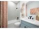 Bathroom with herringbone tile, light blue vanity, and wicker mirrors at 7366 Marathon Dr, Seminole, FL 33777