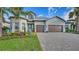 Two-story home with attractive landscaping and a paver driveway at 7872 Mainsail Ln, Sarasota, FL 34240