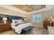 Spacious main bedroom with stylish decor, a large bed, and coffered ceiling at 7872 Mainsail Ln, Sarasota, FL 34240