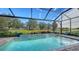 Relaxing screened-in pool with a view of the tranquil backyard at 7872 Mainsail Ln, Sarasota, FL 34240