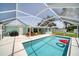 Relaxing pool area with covered patio and colorful furniture at 881 Polaris Rd, Venice, FL 34293