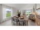 Dining room with wooden table, gray chairs, and large windows at 9100 Tequila Sunrise Dr, Sarasota, FL 34241