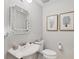 Simple half bathroom with pedestal sink, toilet and bamboo mirror at 9203 Griggs Rd # D103, Englewood, FL 34224