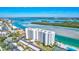 Aerial view of waterfront condo building with pool and tennis court at 9393 Midnight Pass Rd # 704, Sarasota, FL 34242