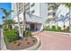 Condo building entrance with landscaping and inviting walkway at 9393 Midnight Pass Rd # 704, Sarasota, FL 34242