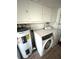 Laundry room with washer, dryer, water heater, and overhead cabinets at 970 S Allendale Ave, Sarasota, FL 34237